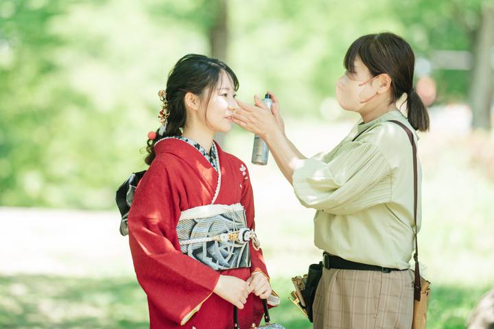 ロケ地で花嫁のヘアメイクを直すスタッフ