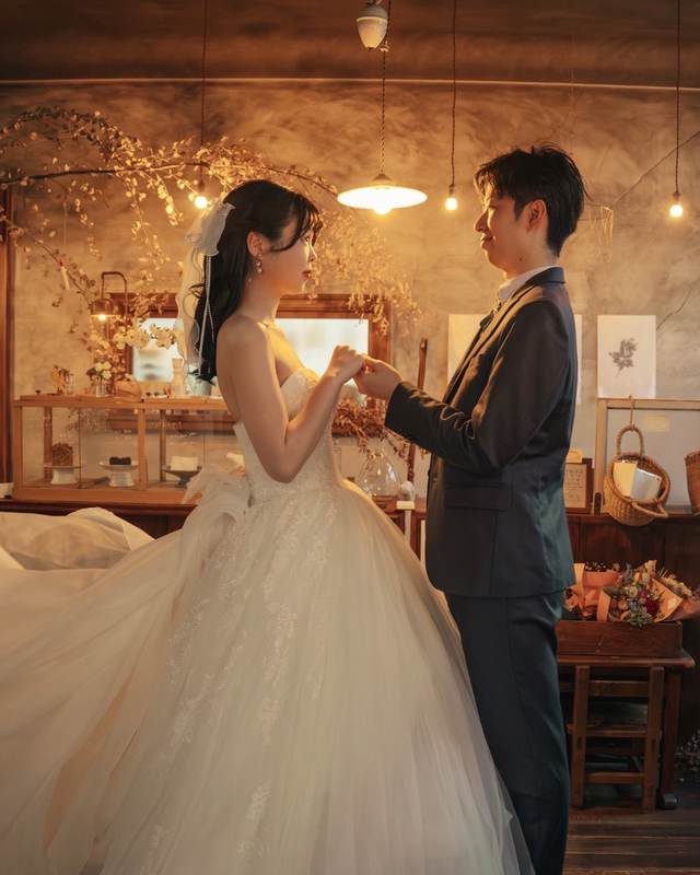 灯りの下でドレスの裾を広げて見つめ合う二人
